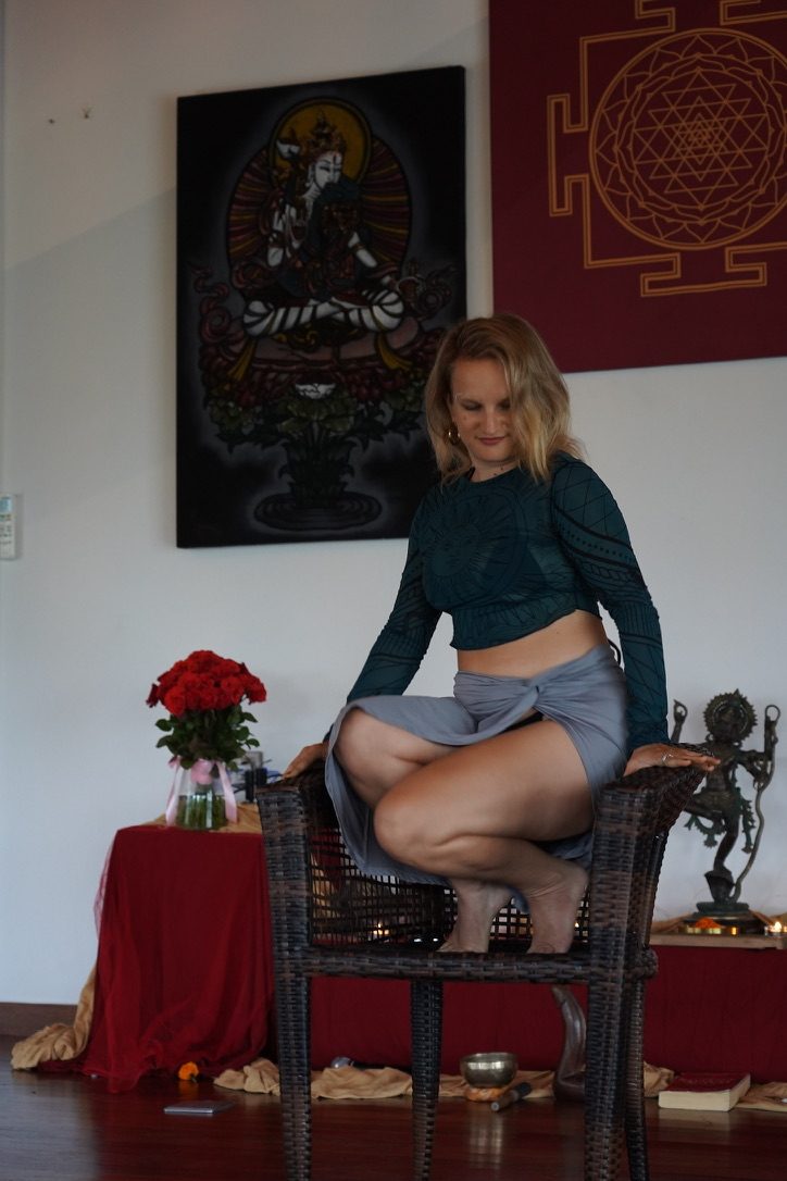 Amanda seated in a tantra room